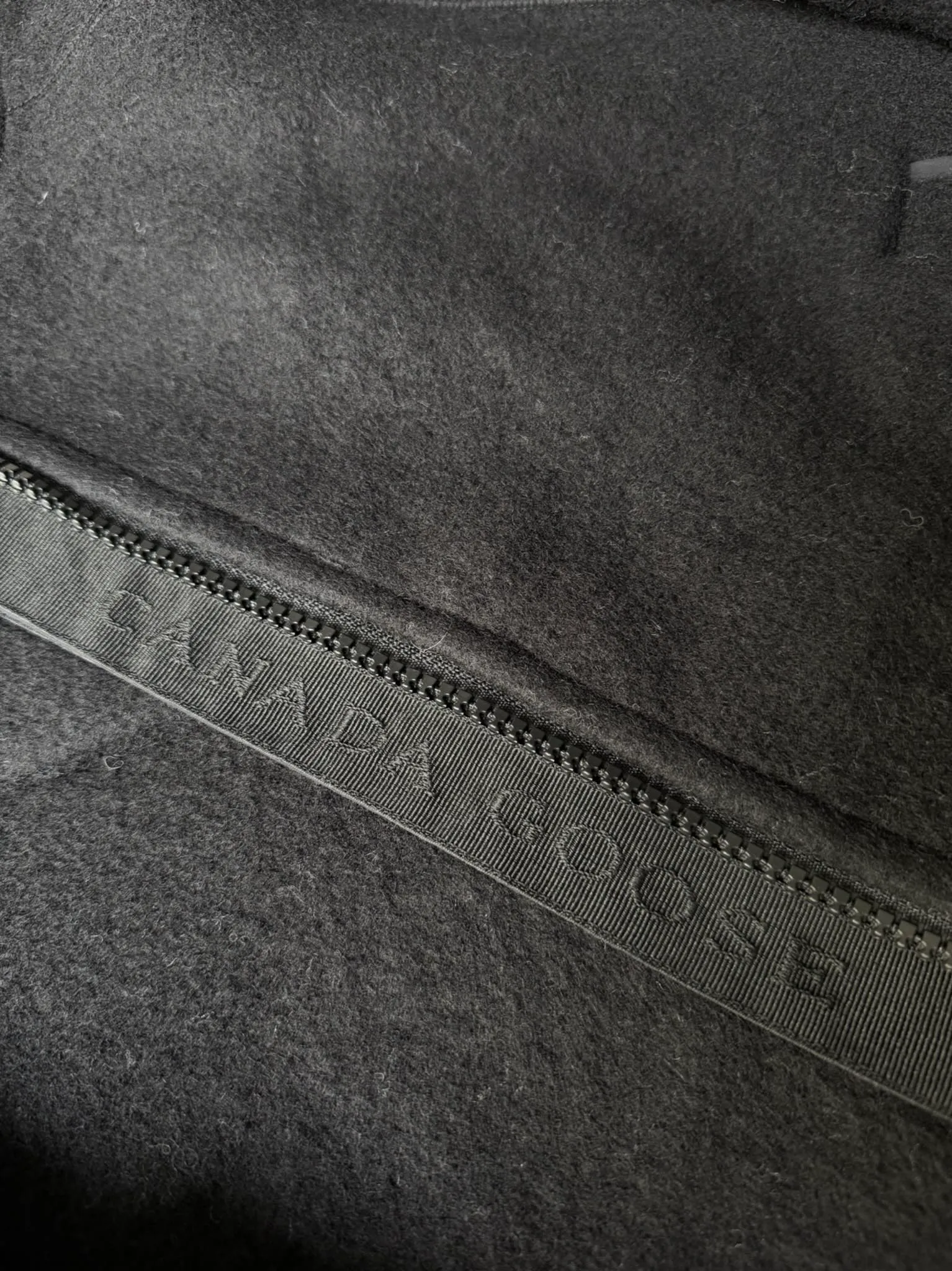 P660 Canada Goose Fleece Wool Badge Hooded Jacket Fabric selection: Wool fleece fabric blended with wool as the main body and a very small amount of spandex and polyester fiber. Wool is a core natural ingredient that provides unparalleled temperature regulation, antibacterial and anti-odor properties and a skin-friendly feel. The feeding of a small amount of spandex gives the fabric a certain degree of four-way elasticity, making it non-restrictive during daily activities. As the basis of fleece's structure, polyester fiber enhances the fabric's durability, wrinkle resistance and quick-drying properties. It contributes to the loft of the fleece and provides functions such as trapping air.  Detail 1: The sleeves and hem are closed with 2×2 ribbing. Its strong elasticity can closely fit wrists and waists of different thicknesses, forming an effective 'seal' to prevent cold wind from blowing back. It can still maintain its original shape after repeated stretching and use, and is not easy to loose and deform. And the ribbed cuffs can convey a sense of design and enhance the visual beauty.  Detail 2: The combination of hood design and elastic buckle improves warmth and windproof performance when wearing. Accessories: Customized elastic drawstring, elastic buckle, custom zipper pendant, custom armband Size: S M L Color: black gray coffee rice pink